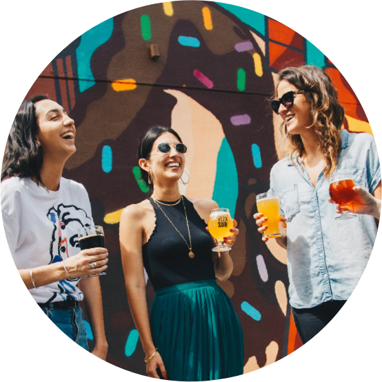 Three women laughing with drinks